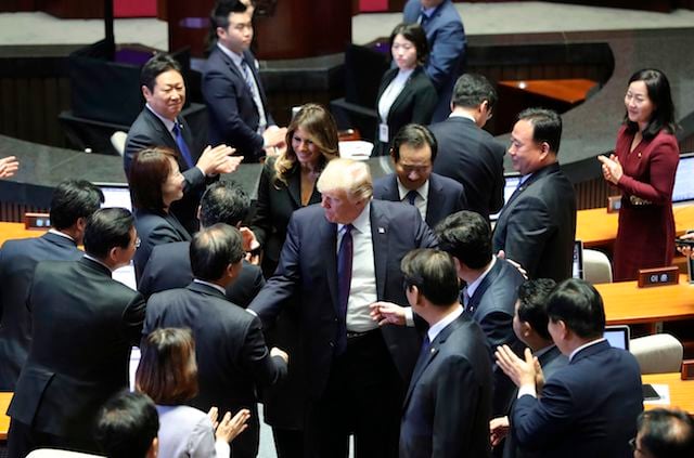 US President Donald Trump (C) and First Lady Melania shake hands with lawmakers as they leave after his speech at the National Assembly in Seoul on November 8, 2017. Trump's marathon Asia tour moves to South Korea, another key ally in the struggle with nuclear-armed North Korea, but one with deep reservations about the US president's strategy for dealing with the crisis. / AFP PHOTO / Lee Jin-man (Photo credit should read LEE JIN-MAN/AFP/Getty Images)
