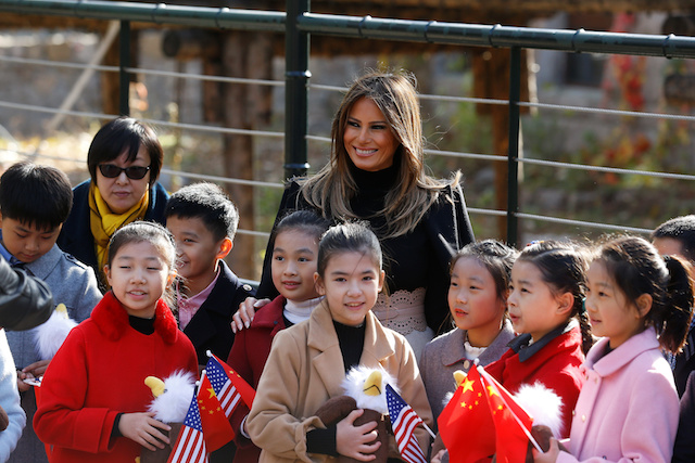 U.S. first lady Melania Trump smiles with children holding U.S. and China flags as she visits Beijing Zoo in Beijing, China, November 10, 2017. REUTERS/Thomas Peter - RC1ABEA26DB0