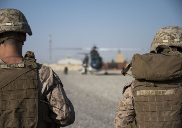 Marines wait to board their flight off of Camp Shorab, in Helmand Province. Marines in Iraq and Afghanistan routinely shoulder between approximately 60 and 120 pounds of gear, including body armor, equipment and weapons. (Hailey Sadler)