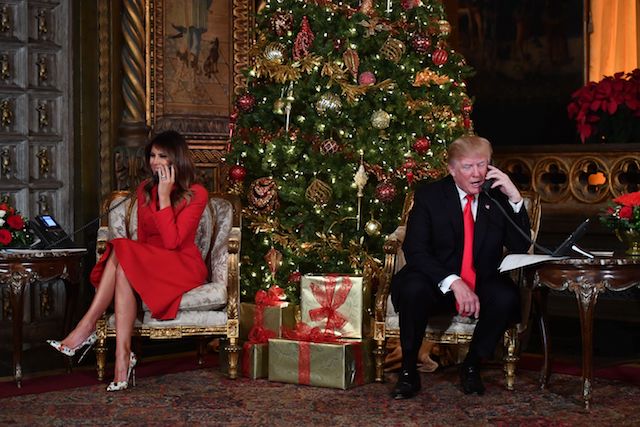 US President Donald J. Trump and the First Lady Melania Trump participate in NORAD Santa Tracker phone calls at the Mar-a-Lago resort in Palm Beach, Florida on December 24, 2017. / AFP PHOTO / Nicholas Kamm (Photo credit should read NICHOLAS KAMM/AFP/Getty Images)