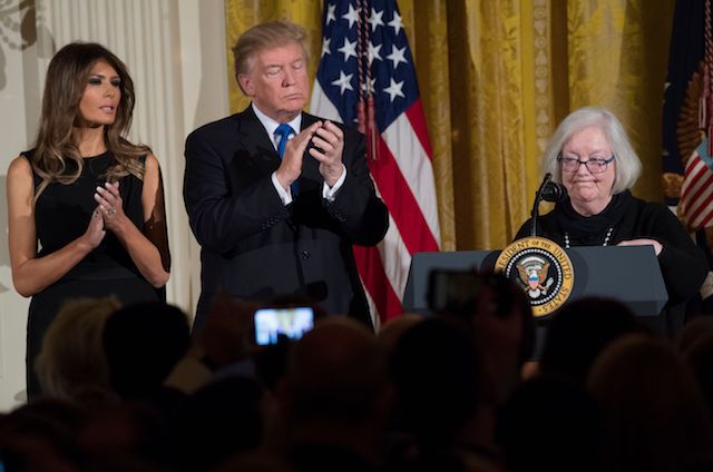 Holocaust survivor Louise Lawrence-Israels (R) speaks alongside US President Donald Trump and First Lady Melania Trump (L) during a Hanukkah reception in the East Room of the White House in Washington, DC, December 7, 2017. / AFP PHOTO / SAUL LOEB