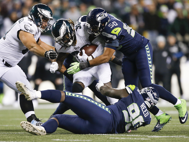 Running back Jay Ajayi #36 of the Philadelphia Eagles is tackled by defensive tackle Jarran Reed #90 of the Seattle Seahawks and K.J. Wright #50 at CenturyLink Field on December 3, 2017 in Seattle. (Photo by Otto Greule Jr /Getty Images)