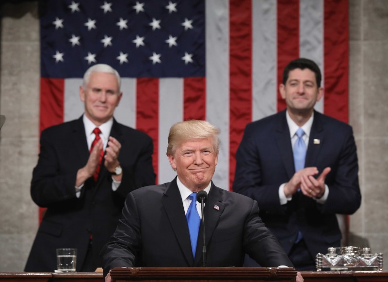 U.S. President Donald J. Trump (C) stands at the podium as U.S. Vice President Mike Pence (L) and Speaker of the House U.S. Rep. Paul Ryan (R-WI) (R) look on during his first State of the Union address to a joint session of Congress inside the House Chamber on Capitol Hill in Washington, U.S., January 30, 2018. REUTERS/Win McNamee/Pool