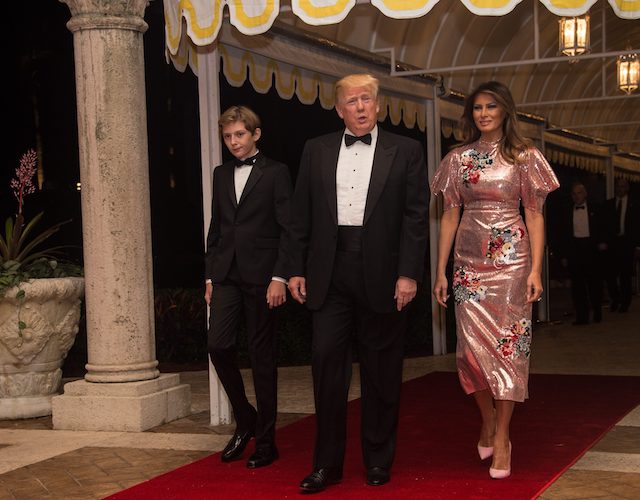 US President Donald Trump, First Lady Melania Trump and their son Barron arrive for a new year's party at Trump's Mar-a-Lago resort in Palm Beach, Florida, on December 31, 2017. / AFP PHOTO / NICHOLAS KAMM (Photo credit should read NICHOLAS KAMM/AFP/Getty Images)