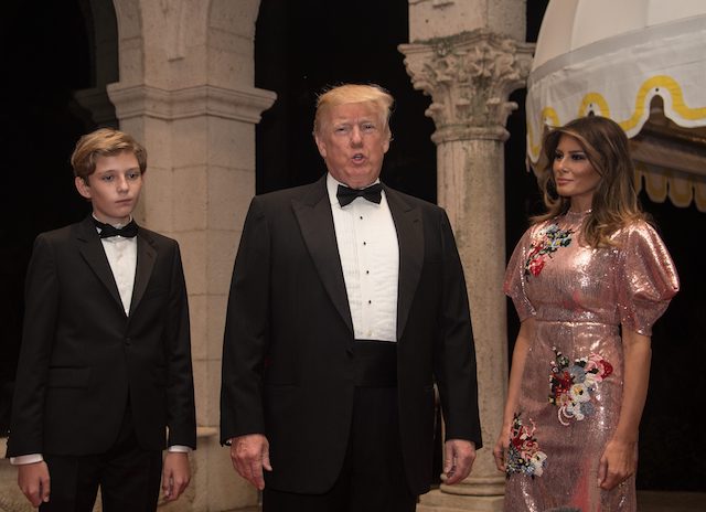 US President Donald Trump, First Lady Melania Trump and their son Barron arrive for a new year's party at Trump's Mar-a-Lago resort in Palm Beach, Florida, on December 31, 2017. / AFP PHOTO / NICHOLAS KAMM (Photo credit should read NICHOLAS KAMM/AFP/Getty Images)