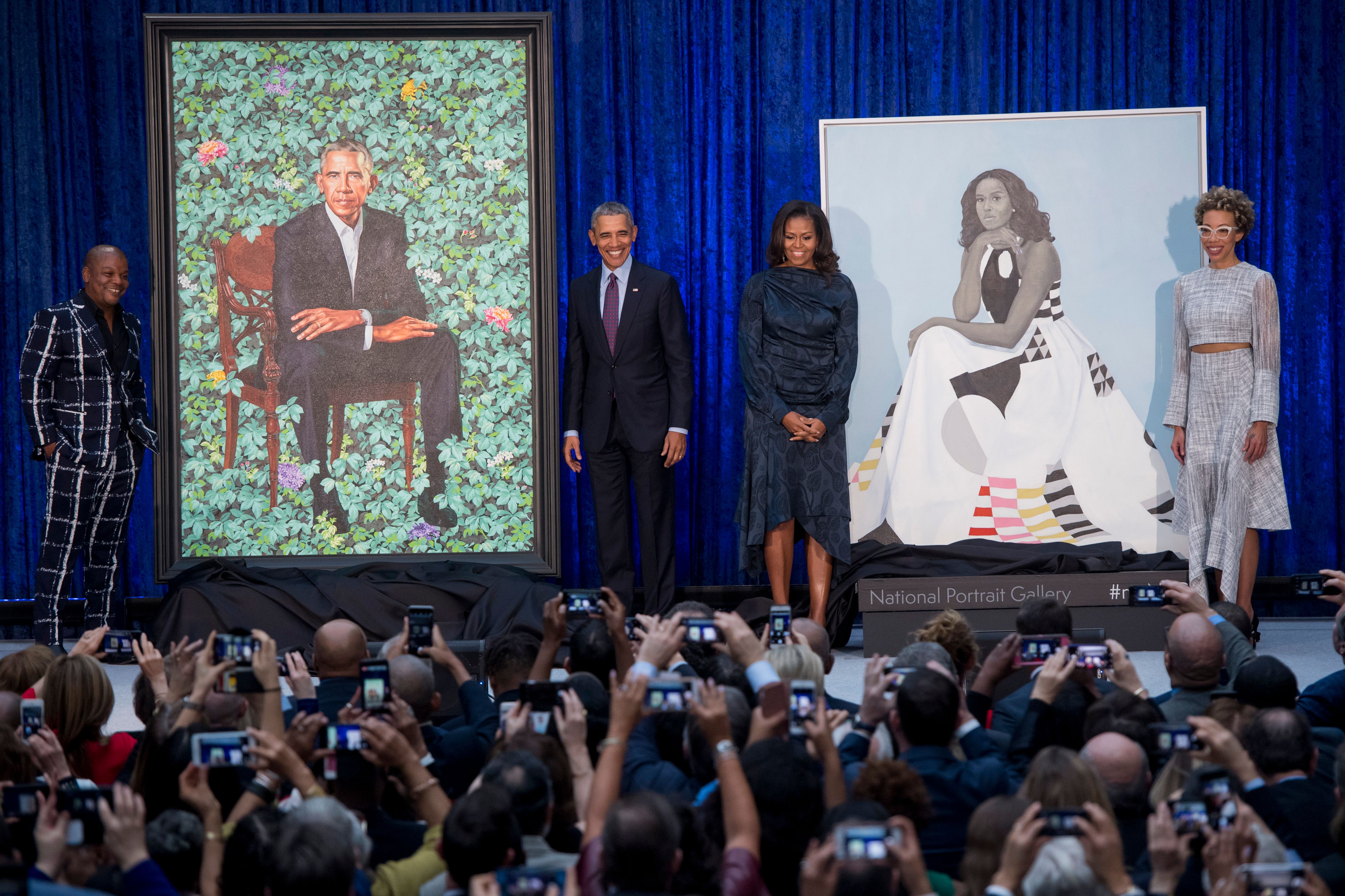 Former US President Barack Obama and First Lady Michelle Obama stand before their portraits and respective artists, Kehinde Wiley (L) and Amy Sherald (R), after an unveiling at the Smithsonian's National Portrait Gallery in Washington, DC, February 12, 2018. GETTY IMAGES / AFP PHOTO / SAUL LOEB