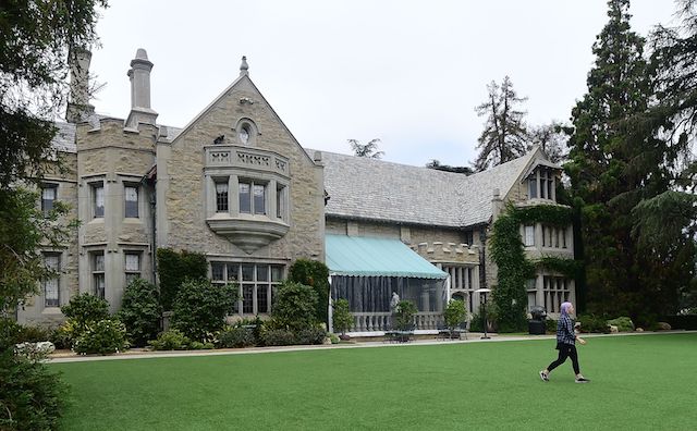 A woman walks across a lawn at the Playboy Mansion in Holmby Hills, Los Angeles, California on May 11, 2016. / AFP / FREDERIC J. BROWN (Photo credit should read FREDERIC J. BROWN/AFP/Getty Images)
