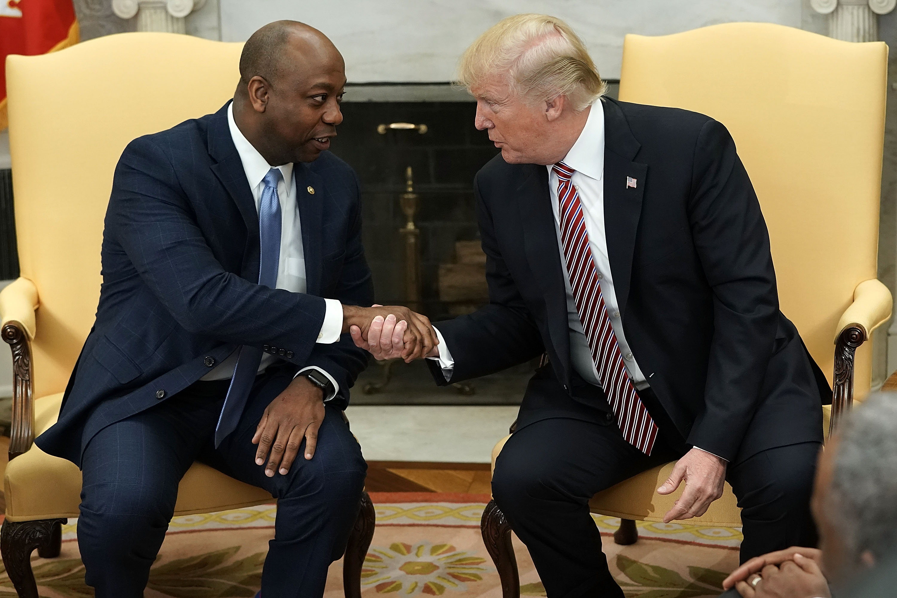WASHINGTON, DC - FEBRUARY 14: U.S. President Donald Trump shakes hands with Sen. Tim Scott (R-SC) during a working session regarding the Opportunity Zones provided by tax reform in the Oval Office of the White House February 14, 2018 in Washington, DC. President Trump hosted a group of local elected officials, entrepreneurs, and investors to discuss "how the 'Opportunity Zones' designation in the Tax Cuts and Jobs Act will spur investment and job growth in distressed communities." (Photo by Alex Wong/Getty Images)