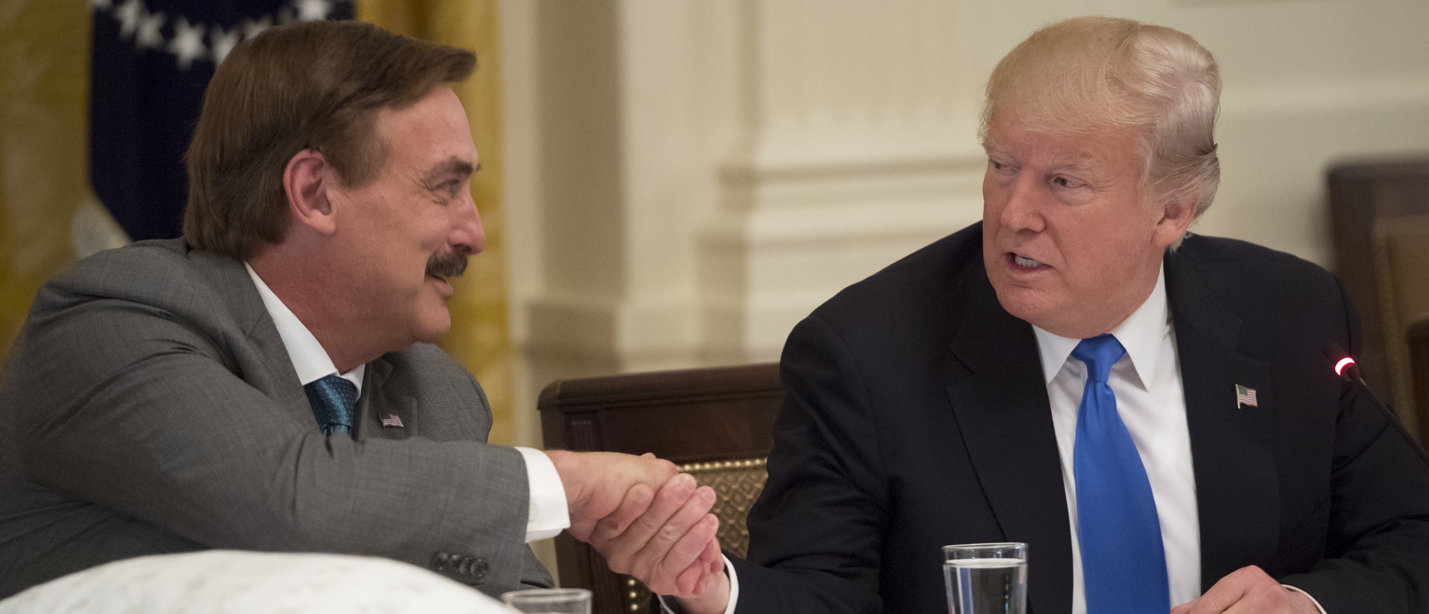 US President Donald Trump shakes hands with Mike Lindell (L), founder of My Pillow, during a Made in America event with US manufacturers in the East Room of the White House in Washington, DC, July 19, 2017. / AFP PHOTO / SAUL LOEB (Photo credit should read SAUL LOEB/AFP/Getty Images)
