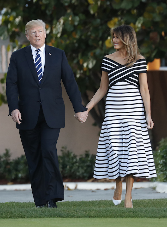 U.S. President Donald Trump and first lady Melania Trump hold hands as walk with Japan's Prime Minister Shinzo Abe and Abe's wife Akie (not pictured) as they arrive for a dinner at Trump's Mar-a-Lago estate in Palm Beach, Florida, U.S., April 17, 2018. REUTERS/Kevin Lamarque - HP1EE4H1T59QL