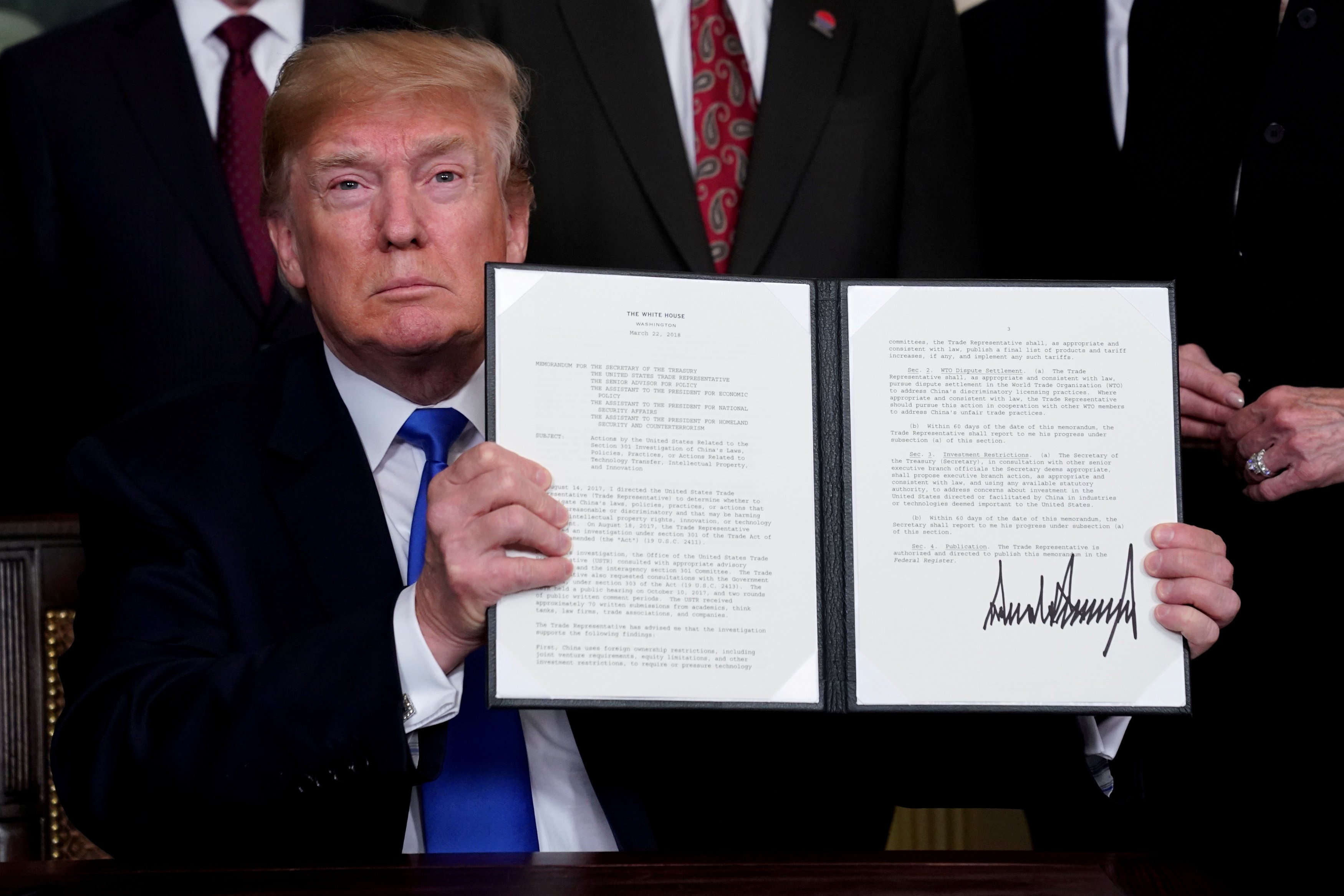 U.S. President Donald Trump holds his signed memorandum on intellectual property tariffs on high-tech goods from China, at the White House in Washington, U.S. March 22, 2018. REUTERS/Jonathan Ernst