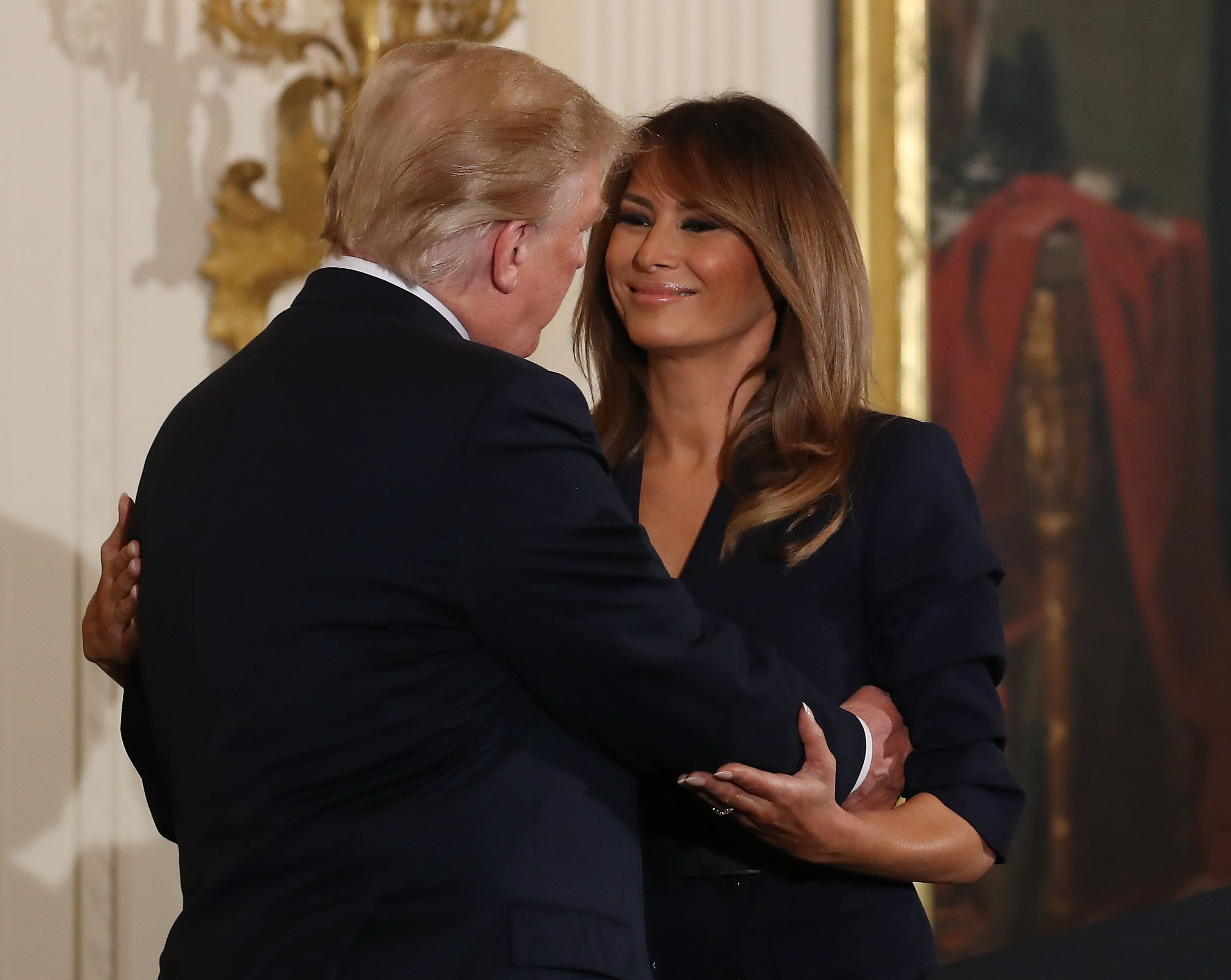 WASHINGTON, DC - MAY 09: U.S. President Donald Trump hugs first lady Melania Trump during an event to celebrate military mothers and spouses, in The East Room at the White House on May 9, 2018 in Washington, DC. (Photo by Mark Wilson/Getty Images)