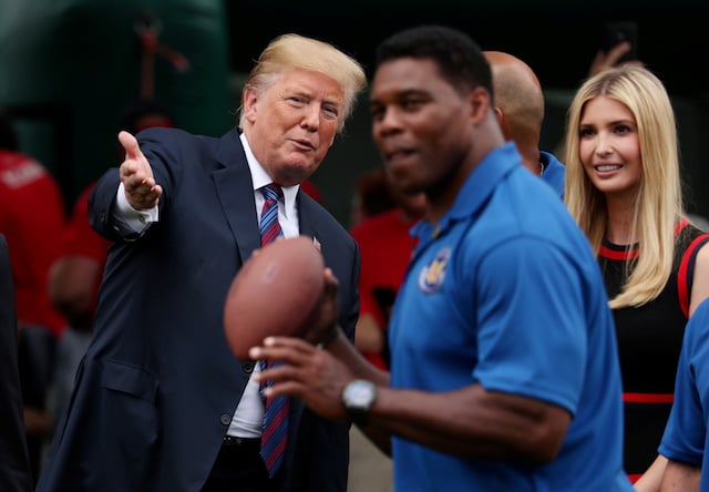 President Donald Trump talks to his daughter and advisor Ivanka Trump as they watch former NFL star Herschel Walker throw a football during the White House Sports and Fitness Day event on the South Lawn of the White House in Washington, U.S., May 30, 2018. REUTERS/Jonathan Ernst - RC1BCB02FEC0
