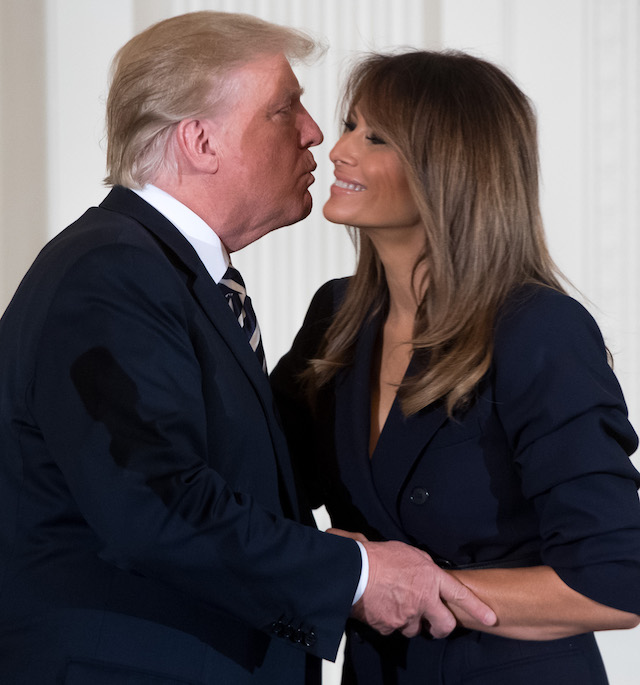 US President Donald Trump embraces First Lady Melania Trump (R) during an event in honor of Military Mothers and Spouses in the East Room of the White House in Washington, DC, May 9, 2018. (Photo by SAUL LOEB / AFP) (Photo credit should read SAUL LOEB/AFP/Getty Images)