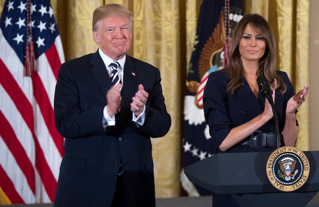 US President Donald Trump stands alongside First Lady Melania Trump (R) during an event in honor of Military Mothers and Spouses in the East Room of the White House in Washington, DC, May 9, 2018. (Photo by SAUL LOEB / AFP) (Photo credit should read SAUL LOEB/AFP/Getty Images)