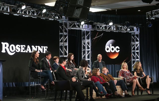 PASADENA, CA - JANUARY 08: (L-R, Back Row) Executive producers Whitney Cummings and Tom Werner, actors Ames McNamera, Emma Kenney, Jayden Rey, executive producer Bruce Helford, (l-r, front row) actor Michael Fishman, executive producer/actress Sara Gilbert, actress Laurie Metcalf, executive producer/actress Roseanne Barr, actors John Goodman, Lecy Goranson and Sarah Chalke of the television show Roseanne speak onstage during the ABC Television/Disney portion of the 2018 Winter Television Critics Association Press Tour at The Langham Huntington, Pasadena on January 8, 2018 in Pasadena, California. (Photo by Frederick M. Brown/Getty Images)