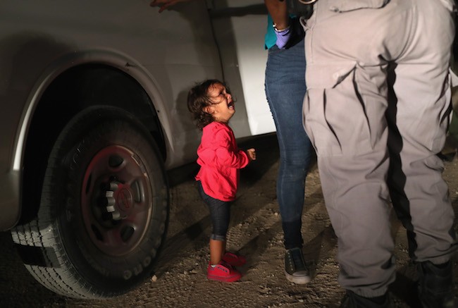 A two-year-old Honduran child cries as her mother is searched and detained near the U.S.-Mexico border on June 12, 2018 in McAllen, Texas. (Photo by John Moore/Getty Images)