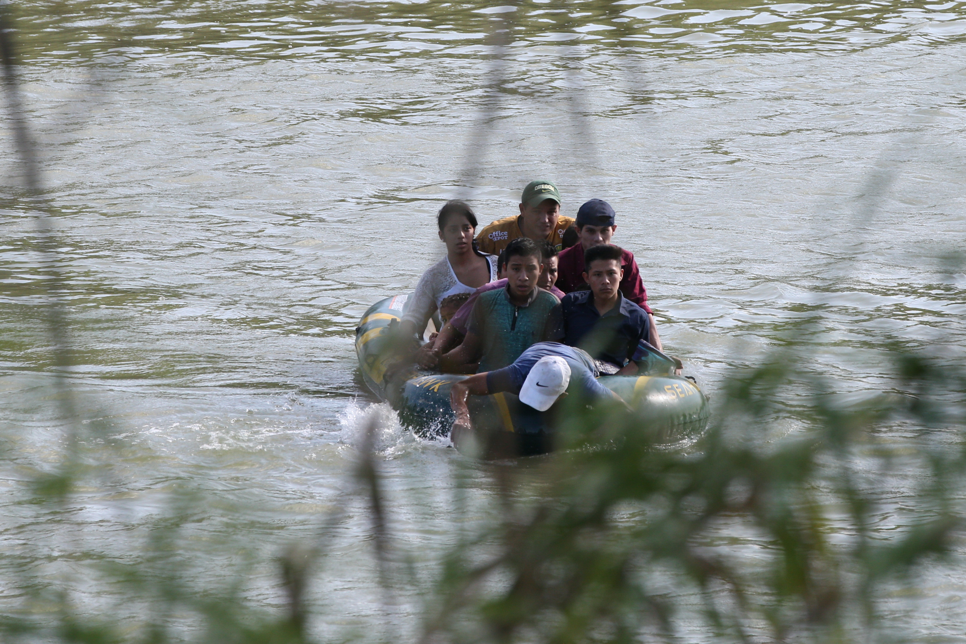 A suspected smuggler uses his arms to paddle a raft of immigrants across the Rio Grande in an illegal crossing of the Mexico-U.S. border near McAllen, Texas, U.S., May 9, 2018. REUTERS/Loren Elliott - RC180A119780