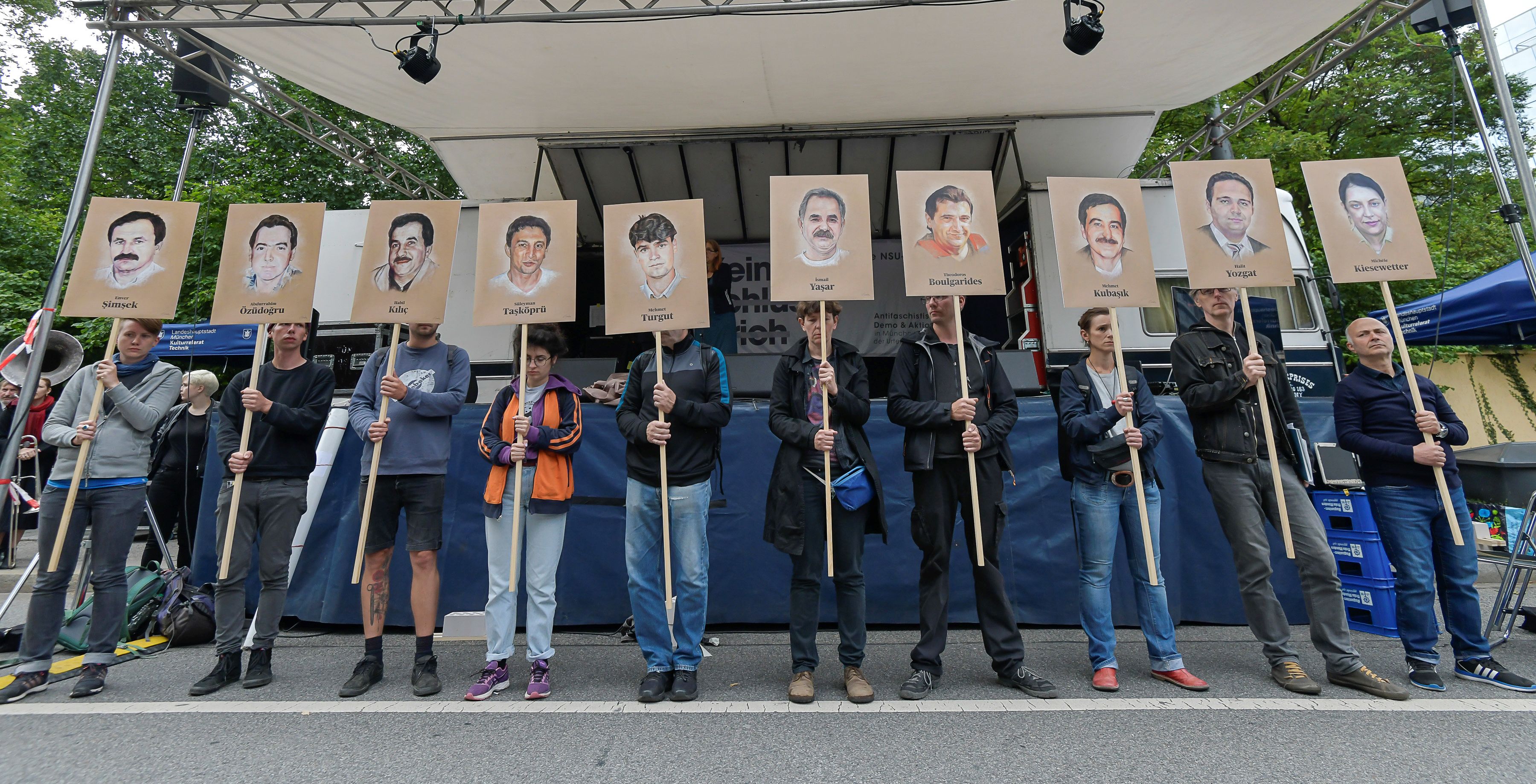 Protesters hold up signs with pictures of the victims of neo-Nazi cell National Socialist Underground (NSU) before the proclamation of sentence in the trial against Beate Zschaepe, the only surviving member of the NSU behind a string of racist murders, in Munich, Germany, on July 11, 2018. - Zschaepe, 43, is accused of complicity in 10 deadly shootings of mostly Turkish and Greek-born immigrants carried out by clandestine trio the National Socialist Underground (NSU). (Photo by Gunter SCHIFFMANN / AFP) (Photo credit should read GUNTER SCHIFFMANN/AFP/Getty Images)