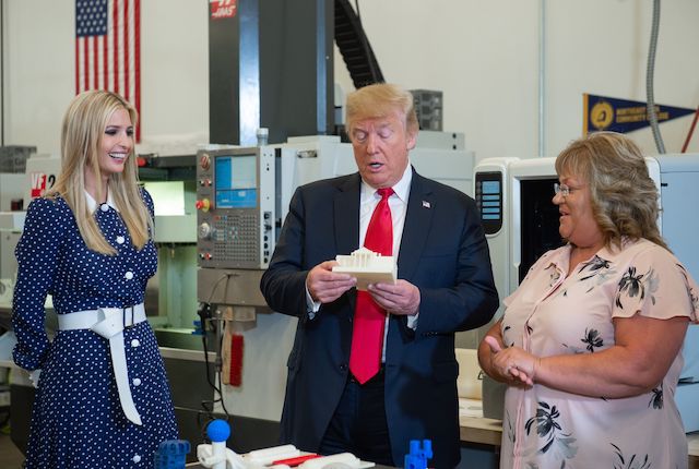 US President Donald Trump holds a 3D printed miniature White House, alongside Ivanka Trump (L), as he tours an advanced manufacturing lab at Northeast Iowa Community College in Peosta, Iowa, July 26, 2018. (Photo credit: SAUL LOEB/AFP/Getty Images)