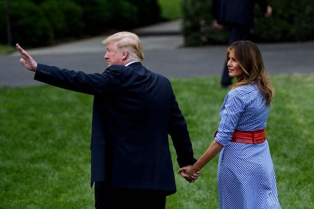 US President Donald Trump (L) leaves with US First Lady Melania Trump after speaking during an Independence Day picnic for military families on the South Lawn of the White House July 4, 2018 in Washington, DC. (Photo credit: BRENDAN SMIALOWSKI/AFP/Getty Images)