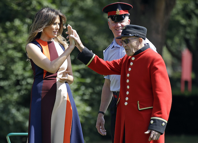 First Lady Melania Trump high-fives with a British military veteran known as a "Chelsea Pensioner" during a game of bowls at Royal Hospital Chelsea on July 13, 2018 in London, England. America's First Lady visited the Chelsea Pensioners while her husband, President Donald Trump, held bi-lateral talks with Theresa May at the Prime Minister's Country Residence. The Chelsea Pensioners are British Army personnel who are cared for at at the Services retirement home at The Royal Hospital in London. (Photo by Luca Bruno - WPA Pool/Getty Images)