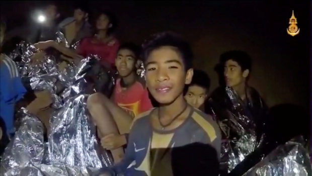 Boys from the under-16 soccer team trapped inside Tham Luang cave covered in hypothermia blankets react to the camera in Chiang Rai, Thailand, in this still image taken from a July 3, 2018 video by Thai Navy Seal. Thai Navy Seal/Handout via REUTERS TV 